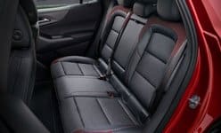 Rear seat of a car with black and red upholstery, showcasing spacious legroom and modern design.