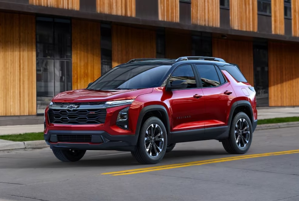 Red Chevrolet SUV parked on an urban street with wooden building facade.
