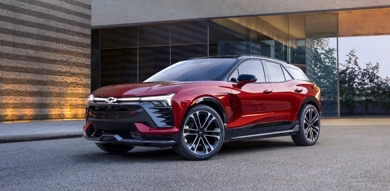 Red Chevrolet SUV parked in front of a modern building, showcasing sleek design and black accents.