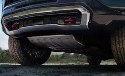 Close-up of a rugged vehicle's undercarriage showing sturdy off-road tires and rear bumper design.