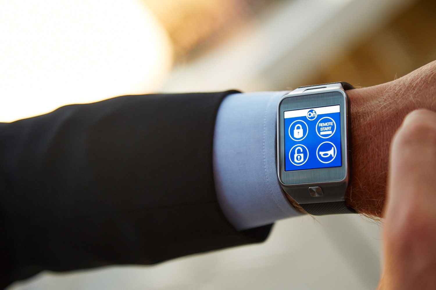 Smartwatch on wrist displaying security app icons, including lock and remote start.